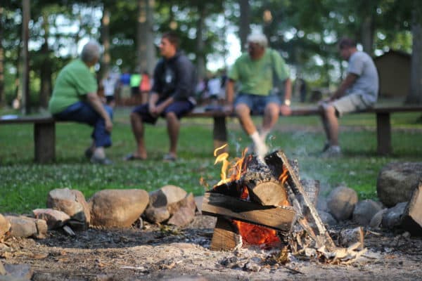 Campers gathered around campfire at Bear Lake Camp